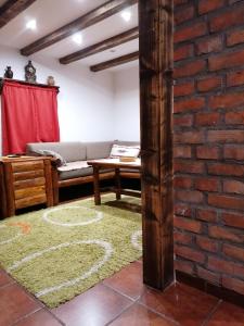 a living room with a couch and a brick wall at Zeleni Breg in Zlatibor