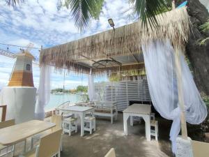 a patio with tables and chairs and a umbrella at I-Talay Zone Sea in Ko Samed