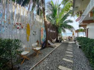 a walkway with chairs and a wall and the beach at I-Talay Zone Sea in Ko Samed