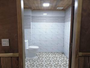 a bathroom with a toilet and a tile floor at Sunshine Hotel Kampot in Kampot