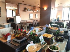 a buffet line with food on display in a restaurant at Smile Hotel Shimonoseki in Shimonoseki