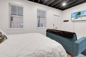 1 dormitorio con 1 cama y 1 silla azul en Housepitality - The Brandenburg Suite - Efficiency, en Columbus