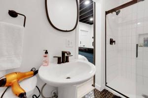 a bathroom with a white sink and a shower at Housepitality - The Brandenburg Suite - Efficiency in Columbus