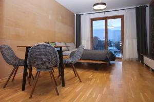 een woonkamer met een tafel, stoelen en een bank bij Apartmán Medvědín 100 in Špindlerův Mlýn