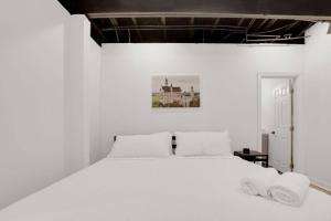 a bedroom with a white bed with two towels on it at Housepitality - The Neuschwanstein Flat in Columbus