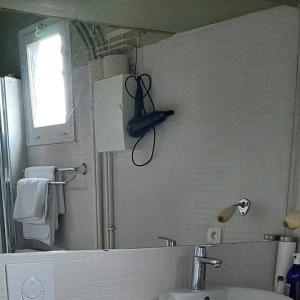 a bathroom with a sink and a pair of scissors on the wall at Chambre d'hôtes Abbatiale in Bernay