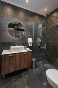 ein Badezimmer mit Waschbecken und Spiegel in der Unterkunft Downtown Luxury Apartments 34 in Ioannina