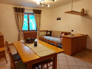 salon z drewnianym stołem i kanapą w obiekcie Appartamenti Osti Sansoni Mariarosa w Andole