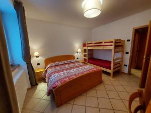 sypialnia z łóżkiem i 2 łóżkami piętrowymi w obiekcie Appartamenti Osti Sansoni Mariarosa w Andole
