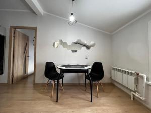 comedor con mesa, sillas y luz en Квартира в центре Костаная, en Kostanái