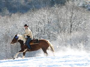 a man riding a horse in the snow at KURNACHATA in Wetlina