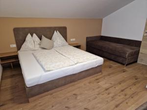 a bedroom with a large bed and a couch at Appartement Sami in Altenmarkt im Pongau