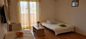 a small room with a bed and a window at Apartments Zakarija in Novalja