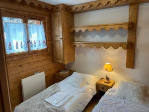 a bedroom with two beds and a table with a lamp at FERMES ESKIMO 1 in Méribel