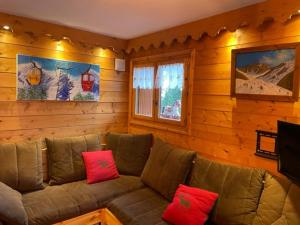 a living room with a brown couch with red pillows at FERMES ESKIMO 1 in Méribel
