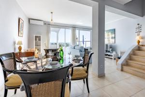 Un comedor y una sala de estar con mesa y sillas. en Bay View Townhouse, en Salema