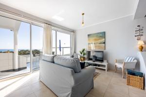 Una sala de estar con un sofá y un televisor. en Bay View Townhouse, en Salema