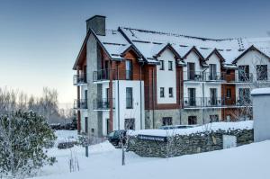an apartment building with snow on the roof at Karkonoskie Widoki in Karpacz