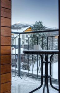 a table on a balcony with snow on the ground at Karkonoskie Widoki in Karpacz