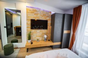 a bedroom with a tv on a brick wall at PleasureLUX MILMARI in Kopaonik