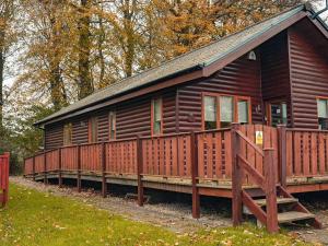 een grote houten hut met een houten terras bij Fir Tree Lodge in Sewerby