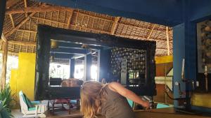 a woman looking at her reflection in a mirror at Paje by Night in Paje