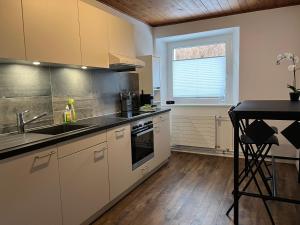 a kitchen with white cabinets and a sink and a window at Schöne, sonnige Parterrewohung 3 Zi. mit Garten in Poschiavo