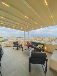 un soggiorno con divano e sedie su un balcone di The Blue Mill Penthouse with Beautiful Views a Naxxar