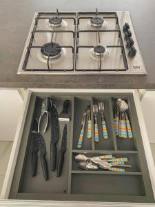 a kitchen drawer with a stove and utensils at The Blue Mill Penthouse with Beautiful Views in Naxxar