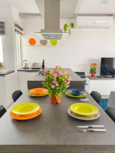 a kitchen with a table with plates and flowers on it at The Blue Mill Penthouse with Beautiful Views in Naxxar