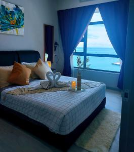 a bed with a bow on it in a room with a window at MLH Designer Suites @ Jesselton Quay CityPads in Kota Kinabalu