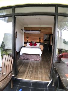 Schlafzimmer mit einem Bett und einer Glastür in der Unterkunft Mount shadows in Ella