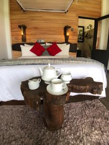 Schlafzimmer mit einem Bett und einem Tisch mit Teezubehör in der Unterkunft Mount shadows in Ella