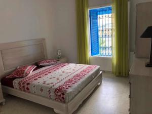 1 dormitorio con 1 cama y una ventana con cortinas verdes en Hammamet northern border (Nabeul), 200m from sea and downtown, en Nabeul
