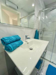 bagno con lavandino bianco e specchio di The Blue Mill Penthouse with Beautiful Views a Naxxar