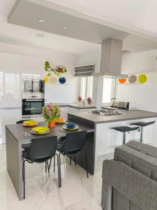 a kitchen with a large island with chairs and a table at The Blue Mill Penthouse with Beautiful Views in Naxxar
