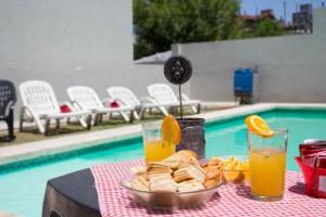 uma mesa com um prato de pastelaria e dois copos de sumo de laranja em Apart Porto del Sol by CPH em Villa Carlos Paz