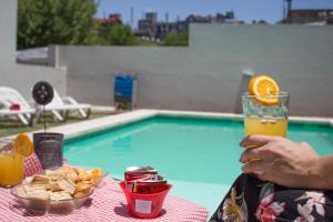 una persona sentada en una mesa con un vaso de zumo de naranja en Apart Porto del Sol by CPH en Villa Carlos Paz