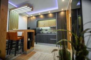 une cuisine avec des armoires noires, une table et des chaises dans l'établissement PleasureLUX MILMARI, à Kopaonik
