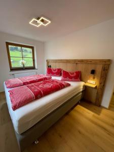 una camera da letto con un letto con cuscini rossi di Schneiderhof a Weerberg