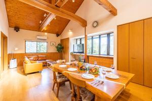 uma grande sala de jantar com uma grande mesa de madeira em Sayuragi Villa 白浜 em Shirahama