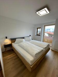 a large bed in a room with a window at Schneiderhof in Weerberg