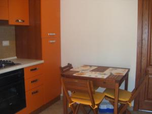 卡沃的住宿－Appartamento Giacomo，厨房配有桌子、两把椅子和炉灶。