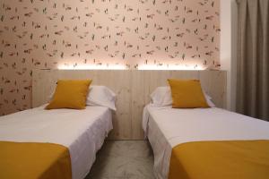 twee bedden naast elkaar in een kamer bij 101 I Posada del Mar I Encantador hostel en la playa de Gandia in Playa de Gandia