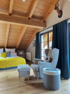 een slaapkamer met een bed en een bank en stoelen bij Das Bergquartier - Ferienwohnung Mühlberg in Oberau