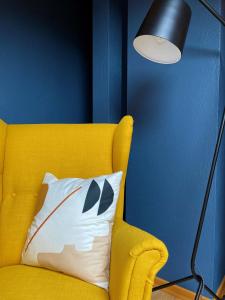 a yellow couch with a pillow next to a lamp at Das Bergquartier - Ferienwohnung Mühlberg in Oberau