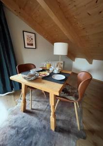 una mesa de comedor de madera con 2 sillas y una lámpara en Das Bergquartier - Ferienwohnung Mühlberg en Oberau