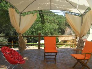 卡沃的住宿－Appartamento Giacomo，天井上配有两把椅子和一把遮阳伞