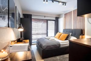 1 dormitorio con cama, escritorio y mesa en Iron Apartments, en Cracovia
