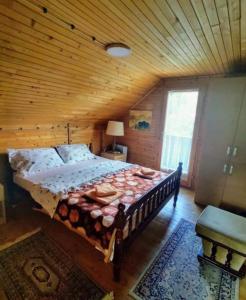 a bedroom with a large bed with a wooden ceiling at Dedinski Raj in Golubac